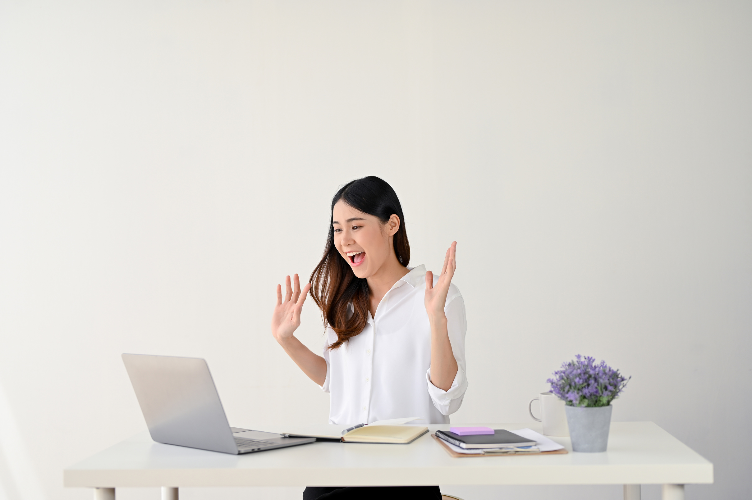 An excited Asian businesswoman receives good news by getting a job promotion letter through email